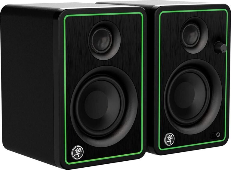 Two black speakers with green trim and speaker components
